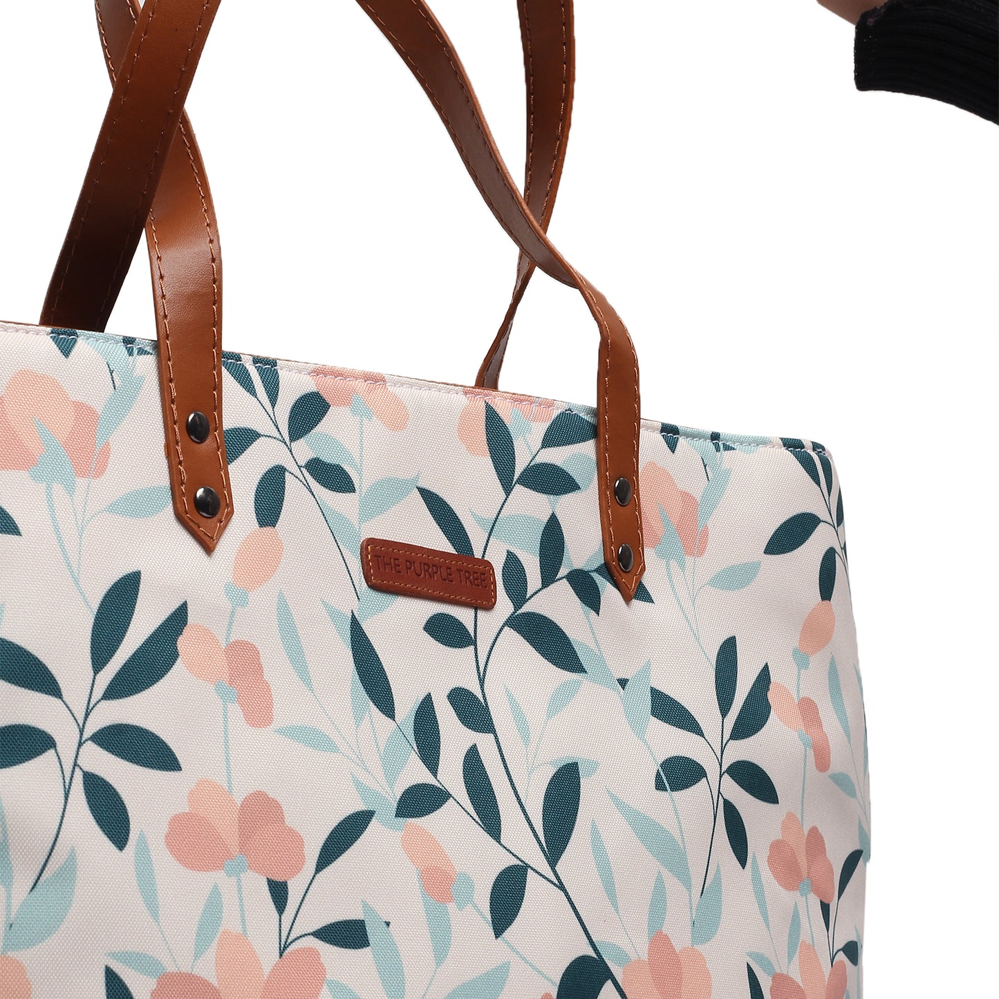 A tote bag with a brown leather handle, featuring a beautiful floral pattern. Perfect for adding a touch of style to any outfit.