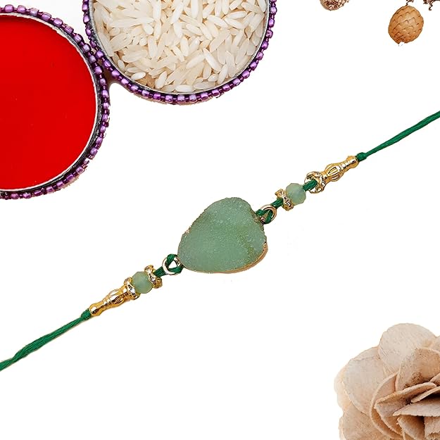 Three green and gold rakhi with beads on a white background.