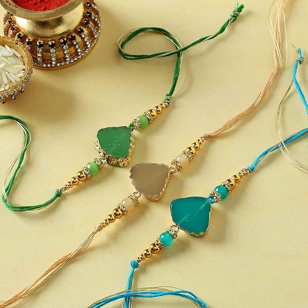 Three green and gold rakhi with beads, representing the bond between siblings.