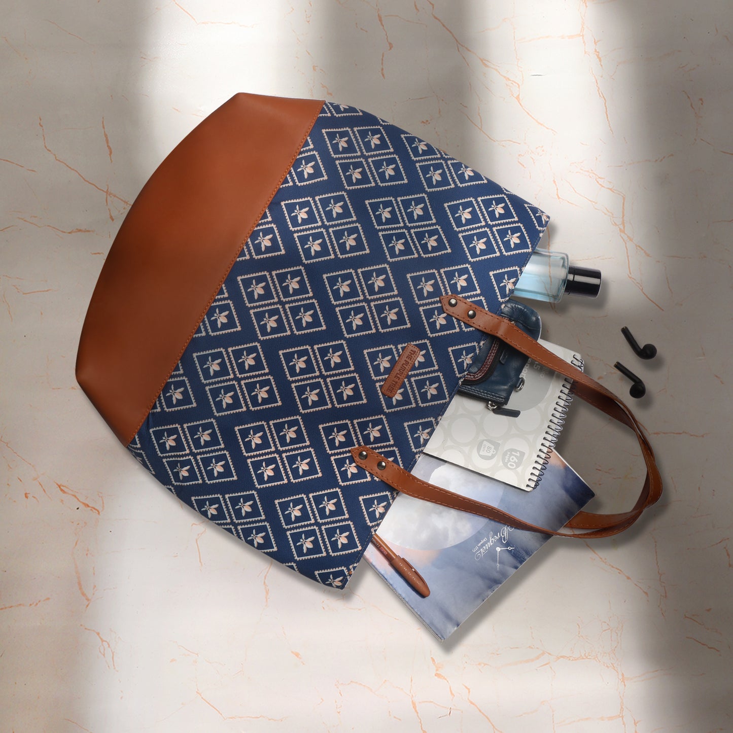 Wooden chair next to a stylish blue and brown tote bag