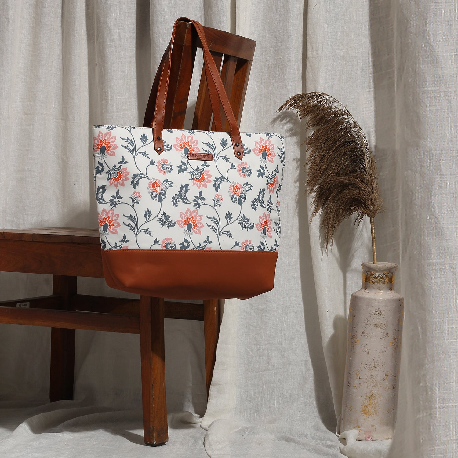 A colorful tote bag with beautiful flowers, resting on a chair. Perfect for adding a touch of nature to your style.