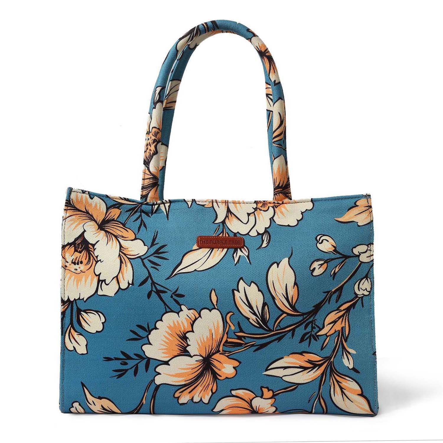 Colorful tote bag with floral design, book, and notebook.