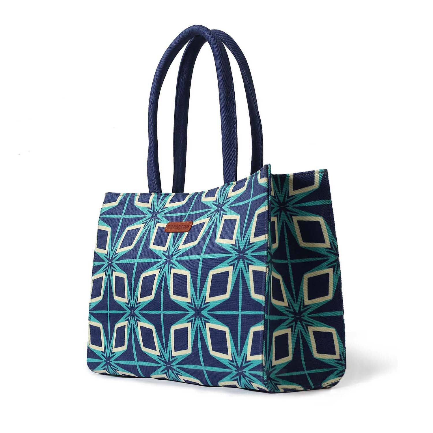 Chic tote bag in blue and green pattern with book and sunglasses.