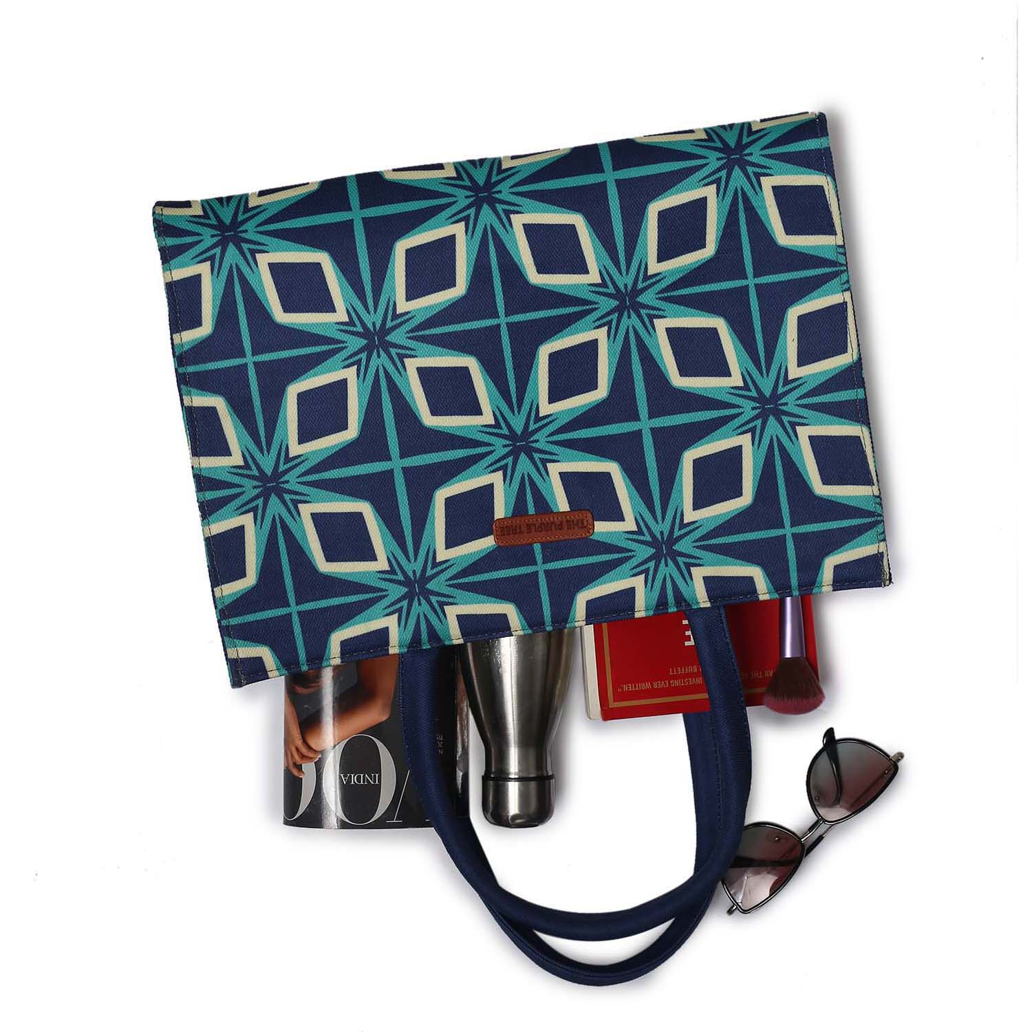 An eye-catching tote bag adorned with a blue and green pattern, accompanied by a book and another book.