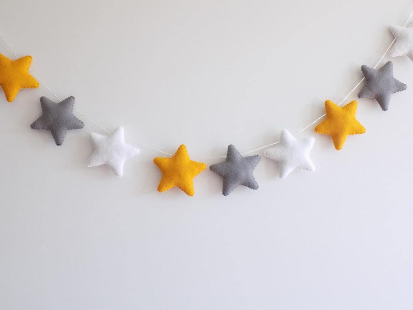 Yellow and gray felt stars garland, a charming addition to your party decorations or craft projects.