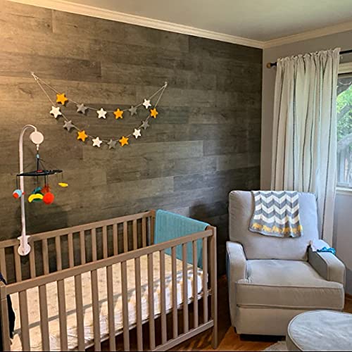 A cozy baby's room with a crib, a comfy chair, and a wall adorned with twinkling stars.