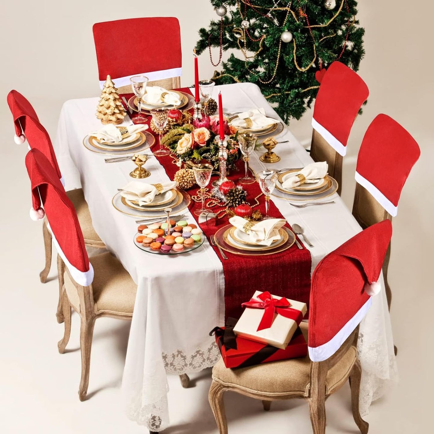 Christmas decorations on a table with four chairs and a tree.