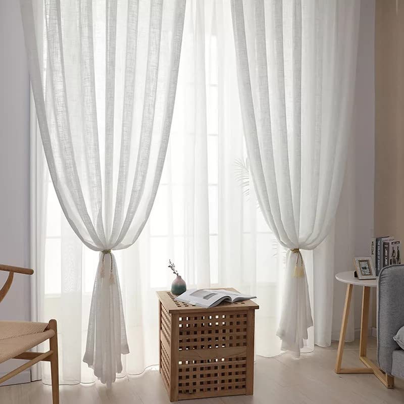 White linen curtains neatly folded on a wooden table.