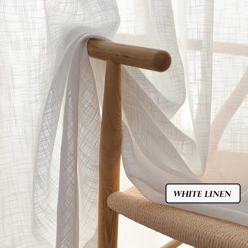 Crisp white linen curtains arranged on a wooden table.