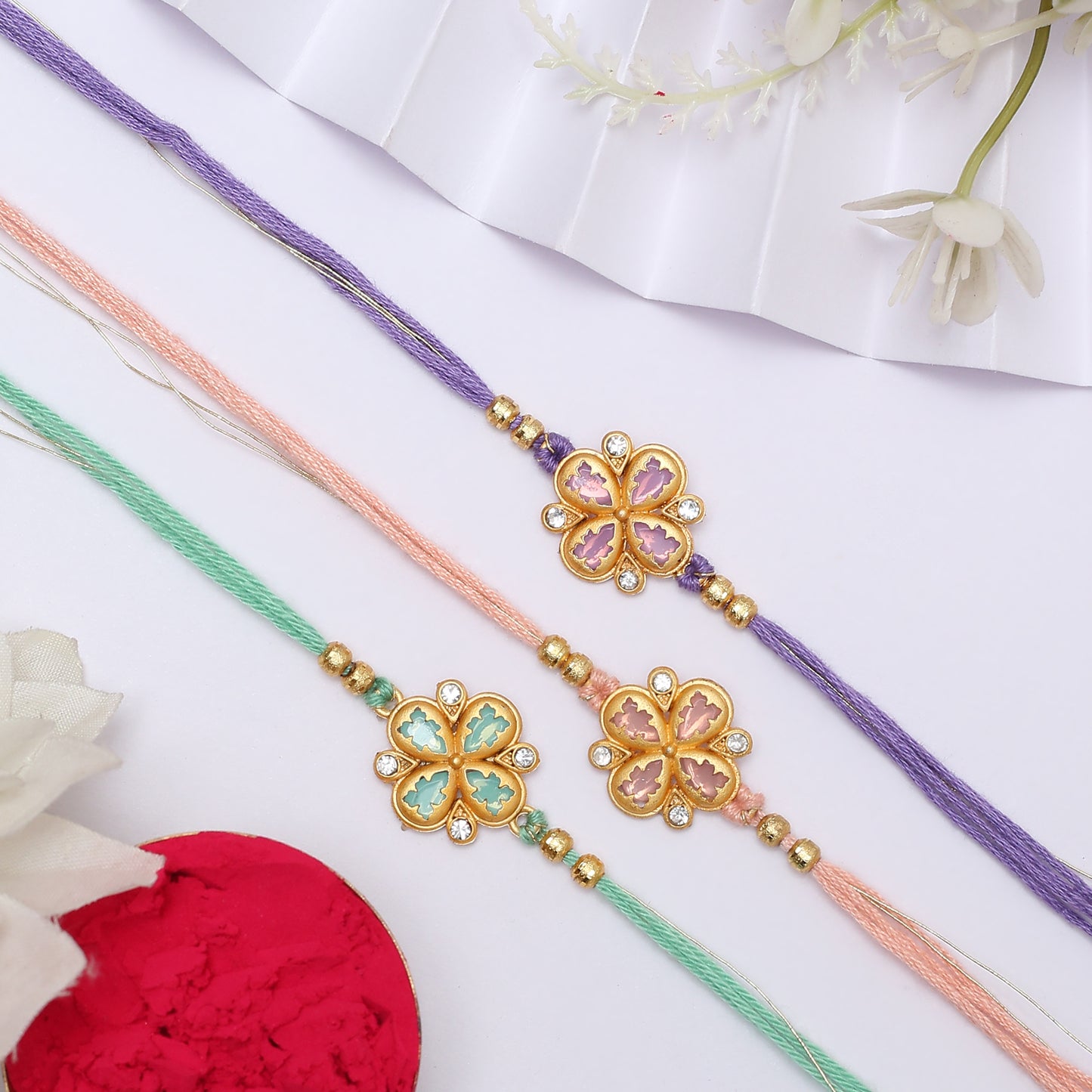 Three vibrant rakhi with gold and pink beads, perfect for celebrating the bond between siblings.