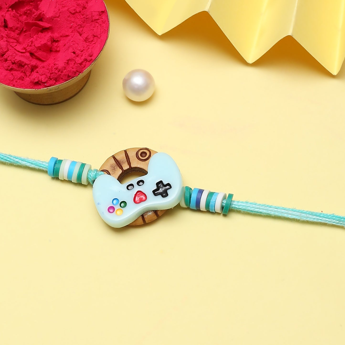 Charm featuring blue and white button design on a Rakhi.