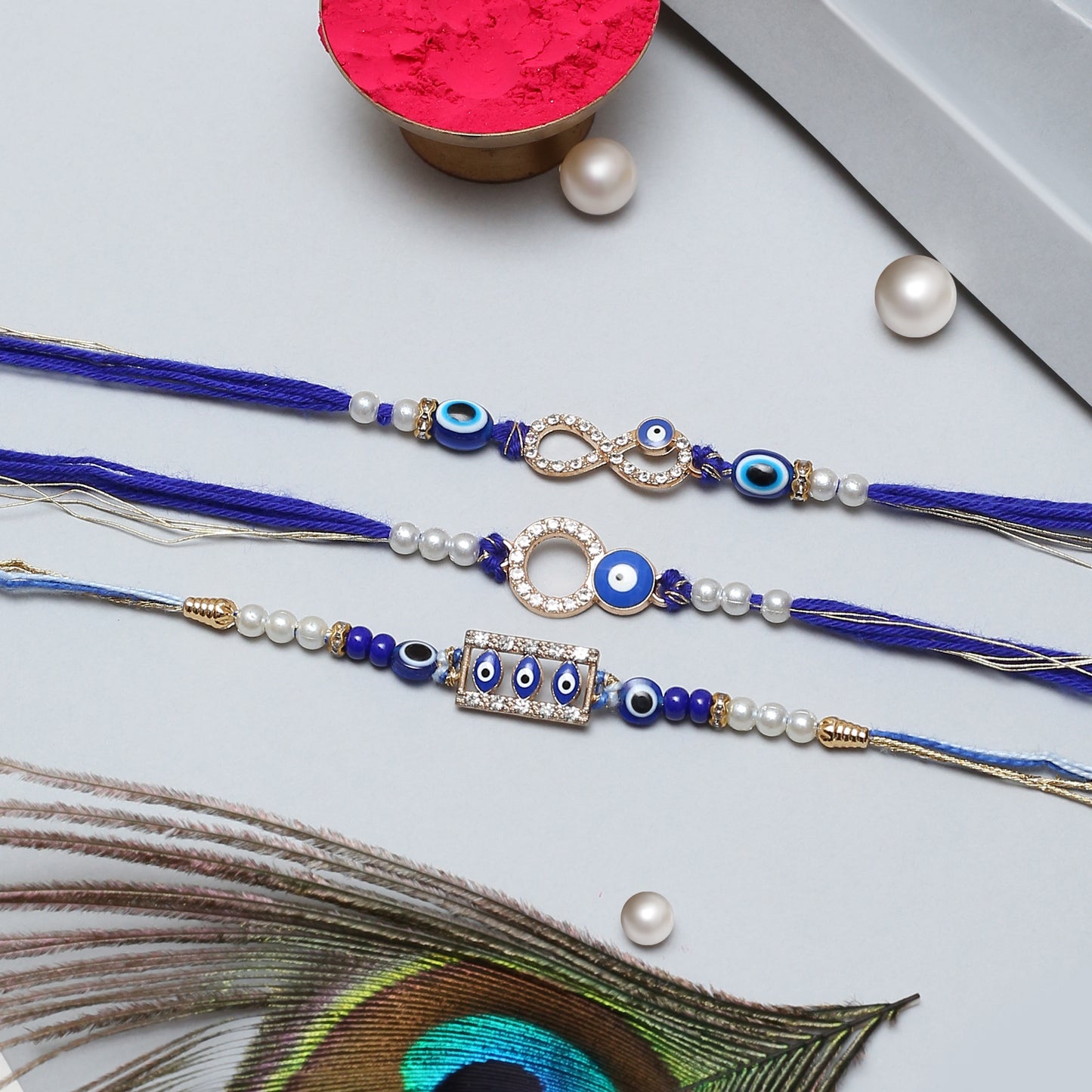 Set of three blue rakhi embellished with pearls and beads, a symbol of sibling love and unity.