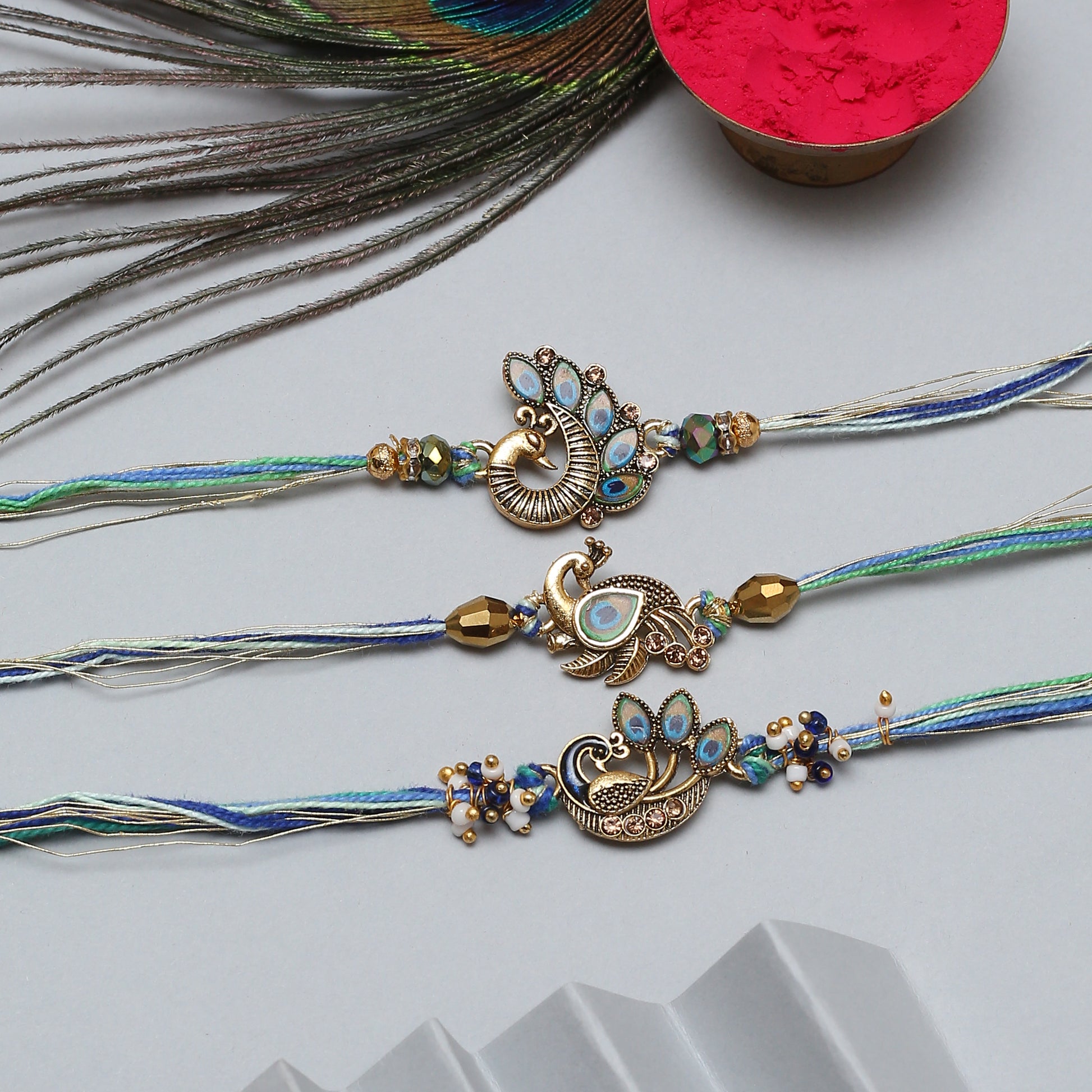 Elegant peacock rakhi set featuring intricate gold and blue beadwork, ideal for Raksha Bandhan.