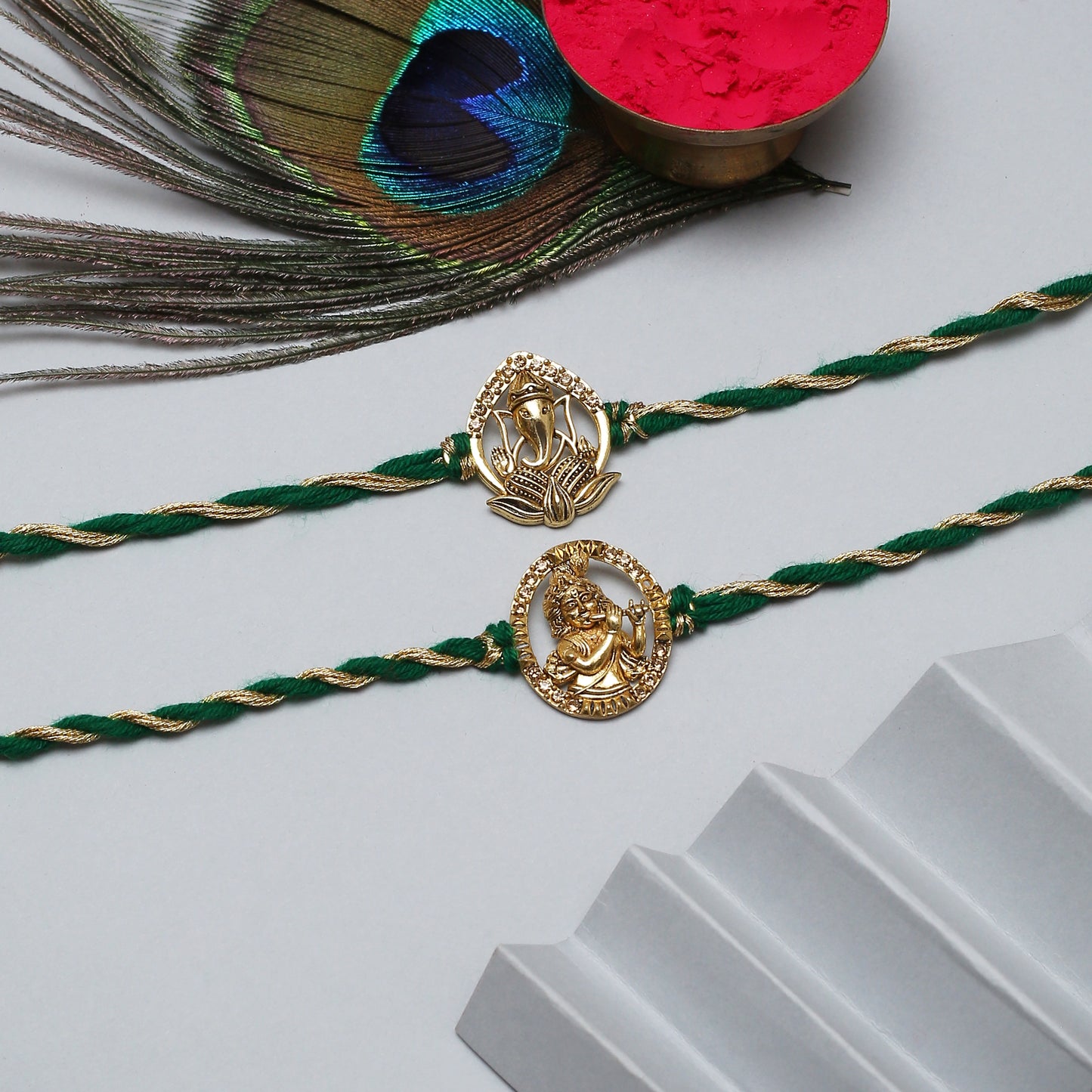 Beautifully crafted gold plated rakhi with green thread, great for Raksha Bandhan.