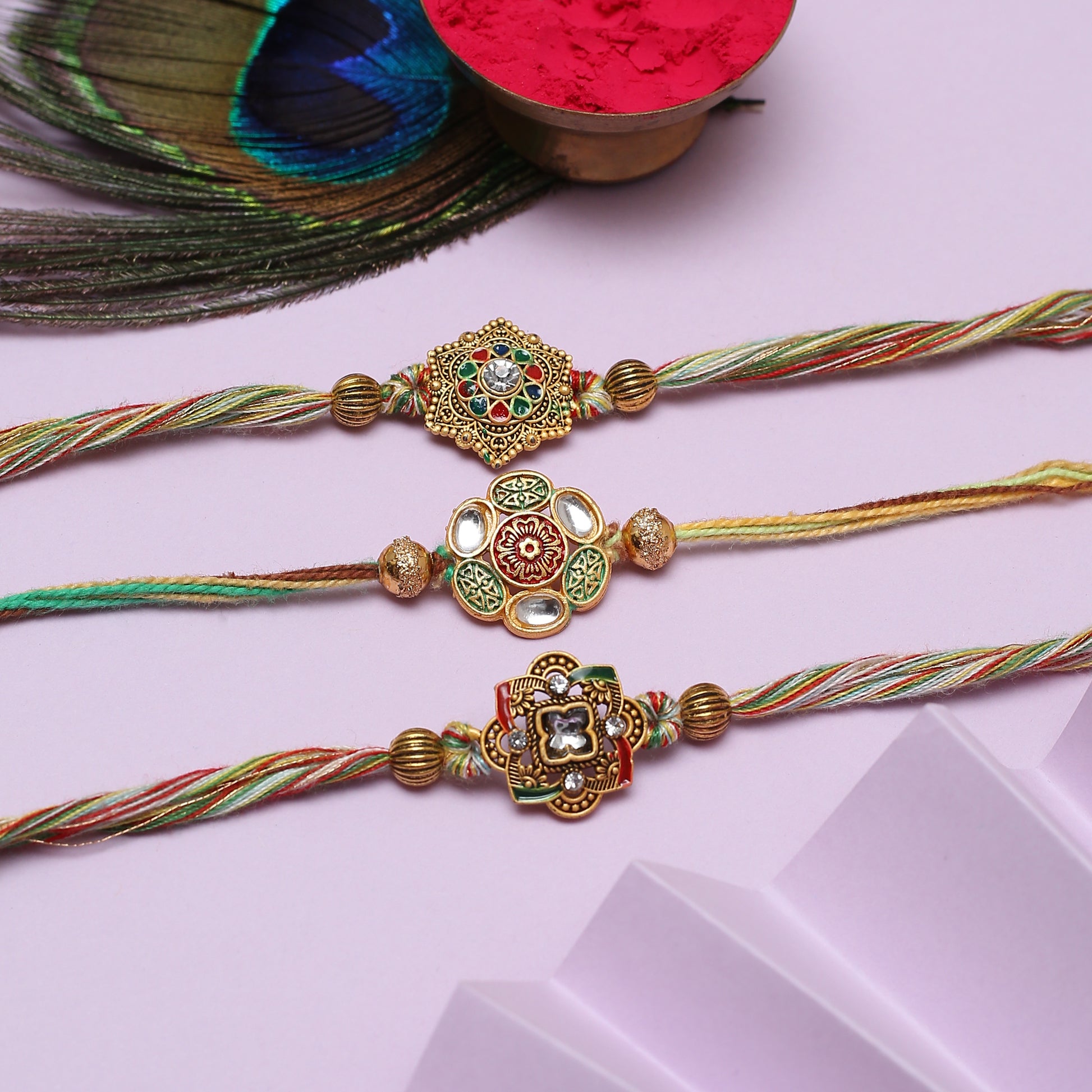 Three colorful rakhi's with a peacock feather - symbolizing love and protection during the festive season.