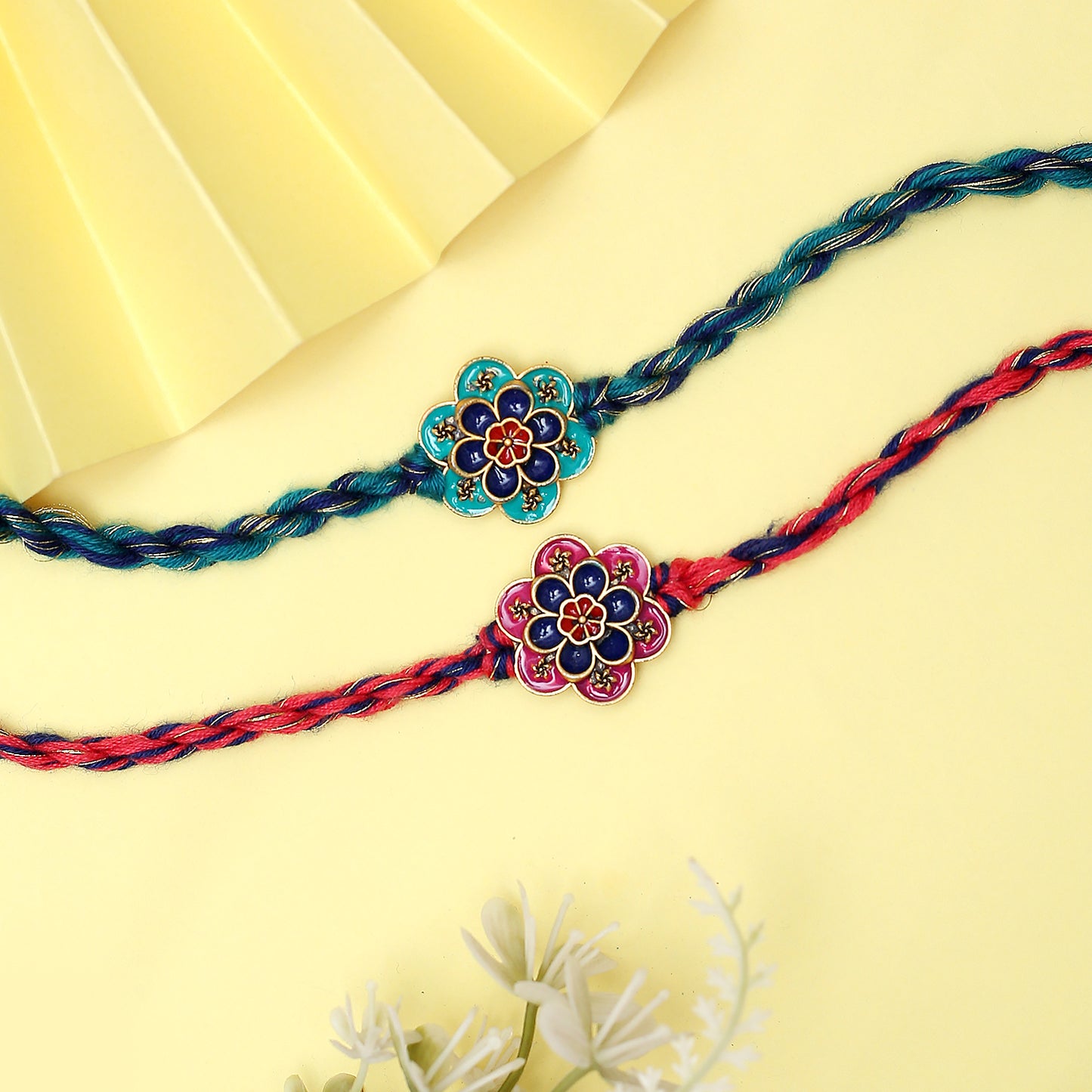 Two vibrant rakhi bracelets with floral patterns.