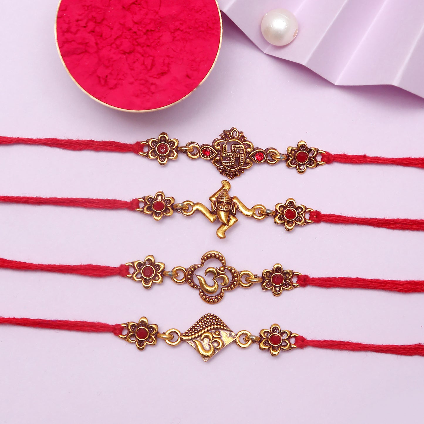 Four red rakhi with gold charms, symbolizing love and protection between siblings during the festival of Raksha Bandhan.