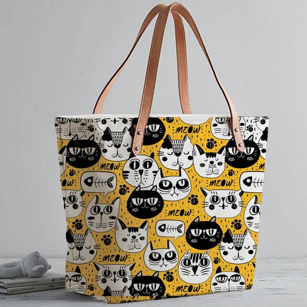 Get ready to turn heads with this trendy tote bag featuring a yellow and black cat pattern.