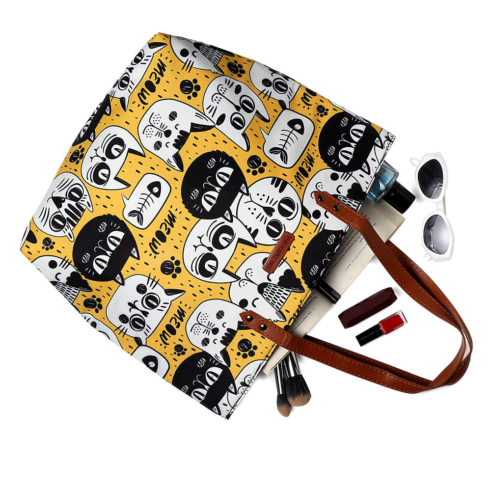 Get ready to turn heads with this trendy tote bag featuring a yellow and black cat pattern.