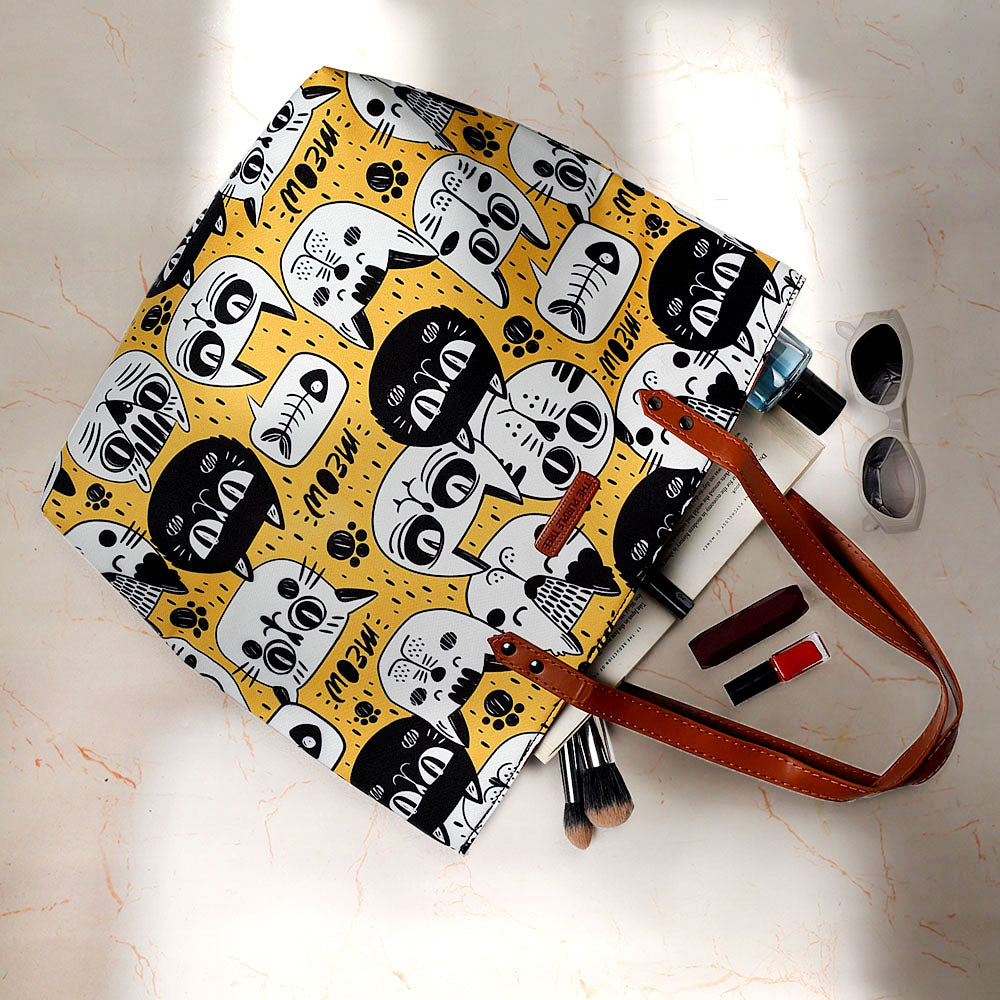 Carry your belongings in style with this eye-catching tote bag adorned with a playful yellow and black cat pattern.