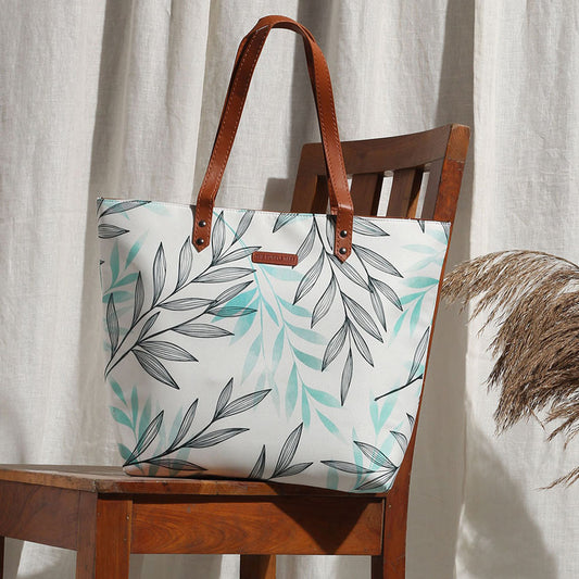 A stylish tote bag with a white and green leaf print design. Perfect for carrying your essentials in style!