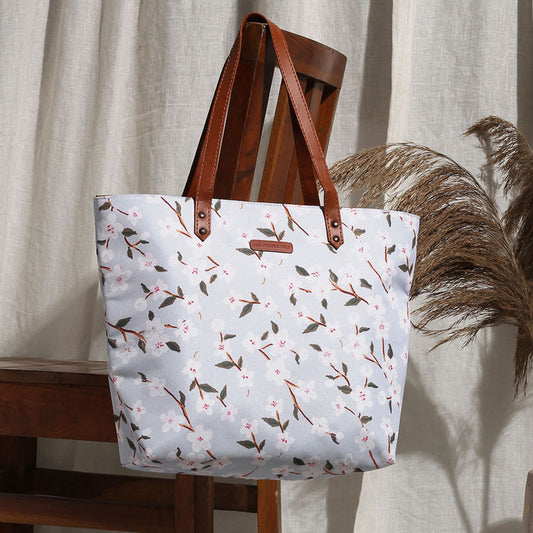 A stylish tote bag with leather handles, featuring a beautiful floral print design. Perfect for any occasion!