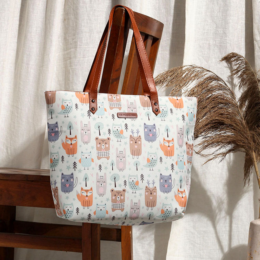 A white tote bag adorned with a delightful pattern of adorable animals. Perfect for animal lovers!