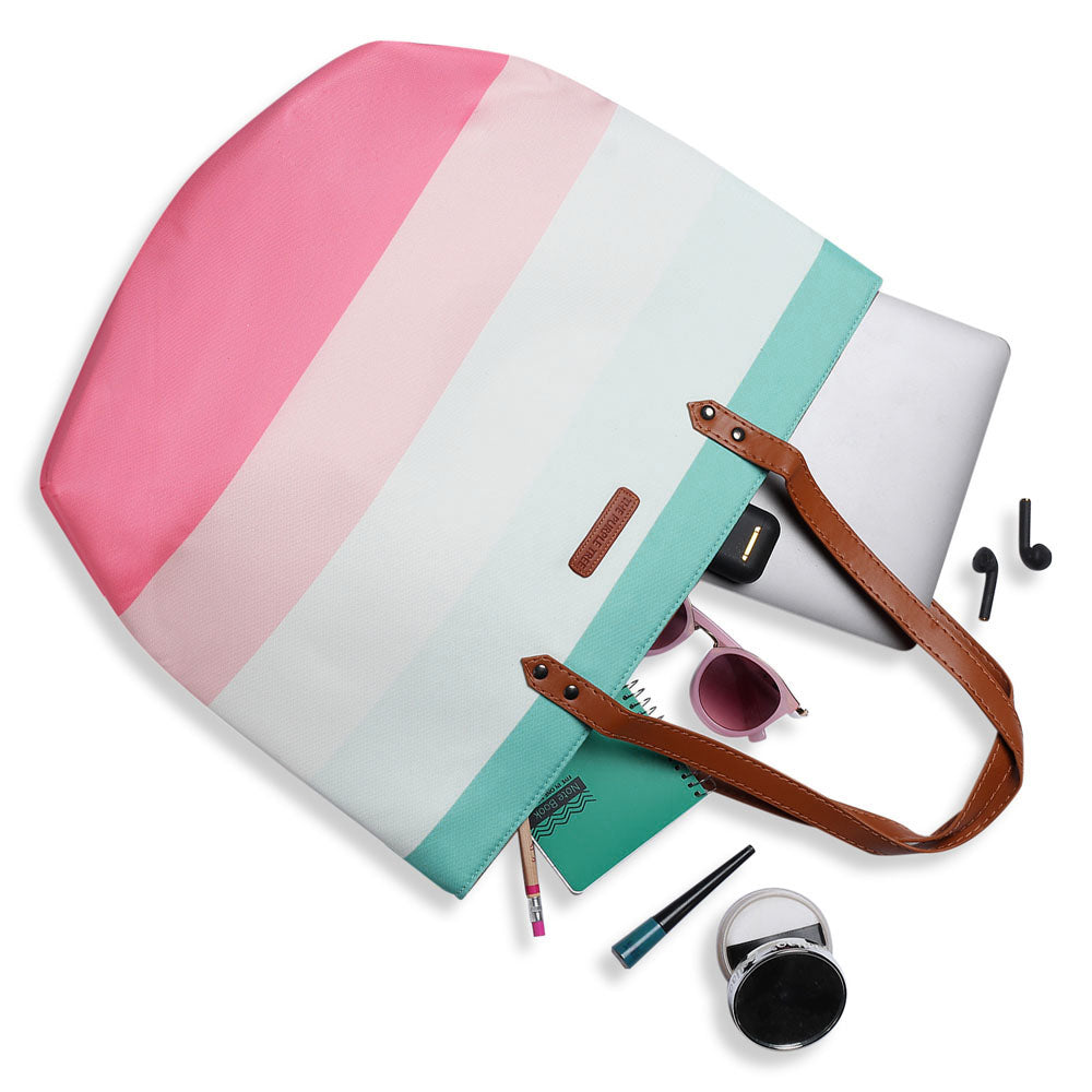  Fashionable tote bag adorned with pink, blue, and white stripes, a versatile accessory for everyday use.