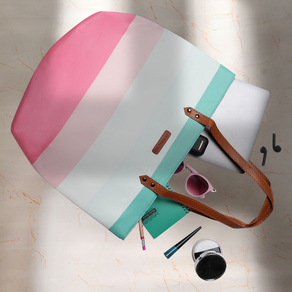  Fashionable tote bag adorned with pink, blue, and white stripes, a versatile accessory for everyday use.