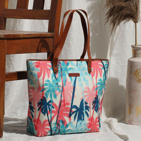 A vibrant tote bag with a palm tree print, showcasing a colorful and tropical design. Perfect for adding a touch of summer to any outfit.