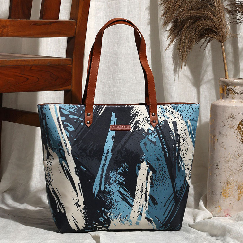 A stylish tote bag with a unique abstract design in blue and white colors. Perfect for adding a touch of art to your everyday look.