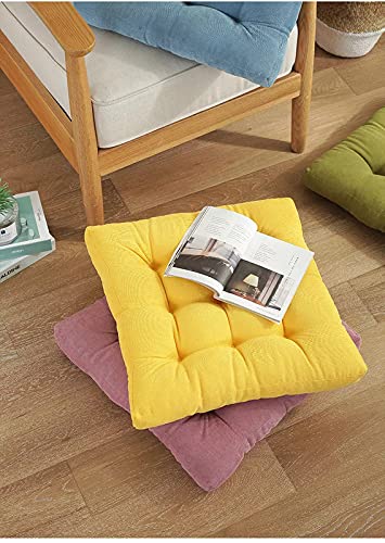 A yellow and pink cushion on a wooden floor.