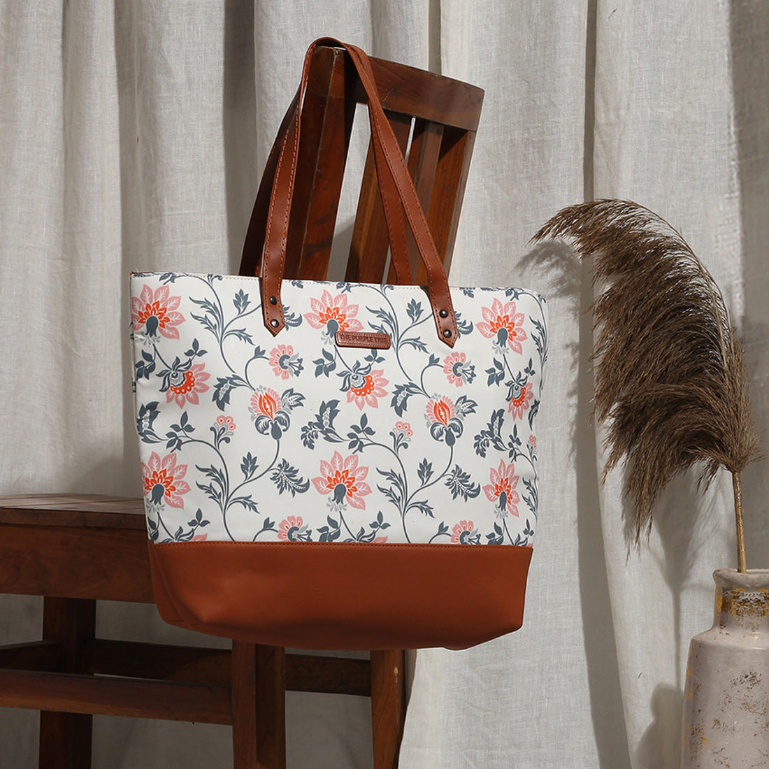 1. Leather floral print tote bag with brown handle.