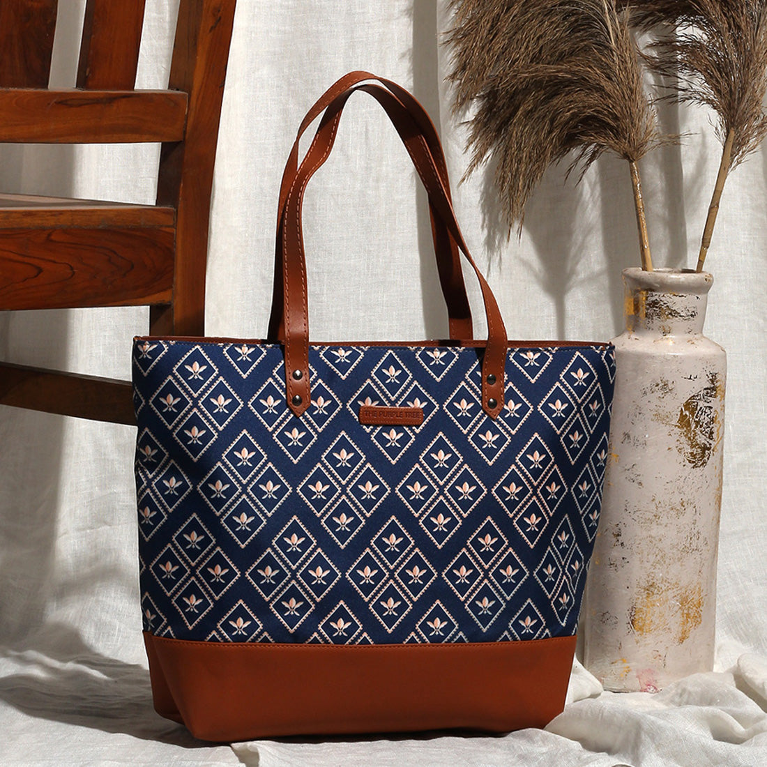 Blue and brown tote bag next to wooden chair