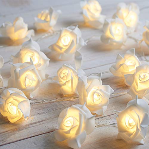 White rose string lights on a wooden table, creating a warm and cozy ambiance.