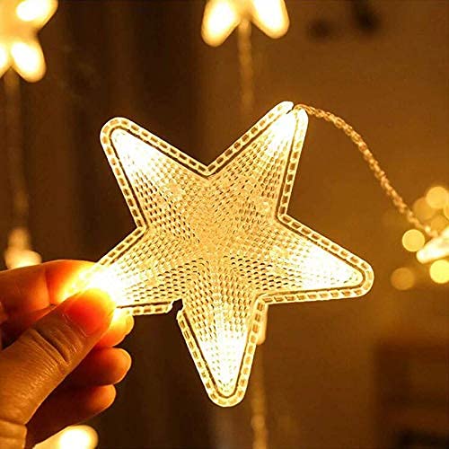  A person holding up a star-shaped string light, adding a warm glow to the room.