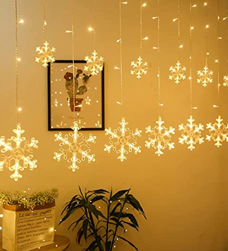 White wall with hanging snowflake decoration in room.