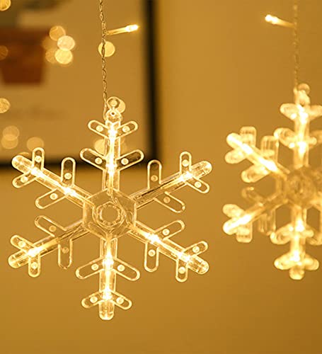 Snowflake hanging on white wall in cozy room.