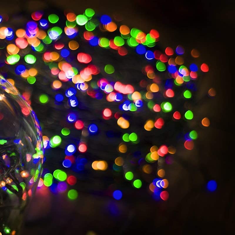 Multicolored lights illuminate a Christmas ball decoration.