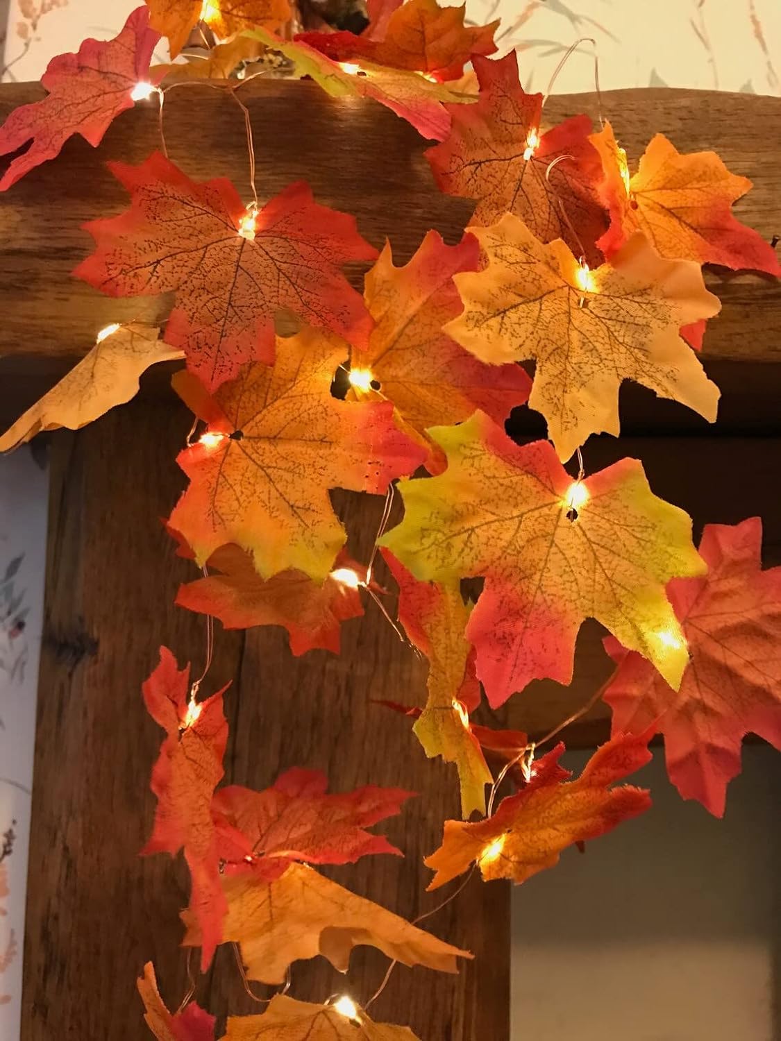 Colorful autumn leaves strung together with twinkling lights for a warm touch.