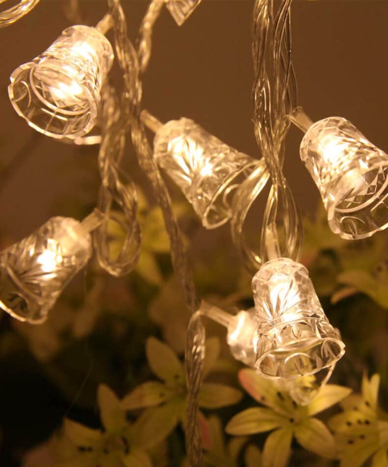  A string of lights with clear glass bells hanging from each light.