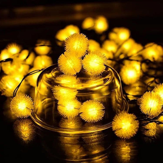 Glass bowl filled with glowing yellow Christmas lights.