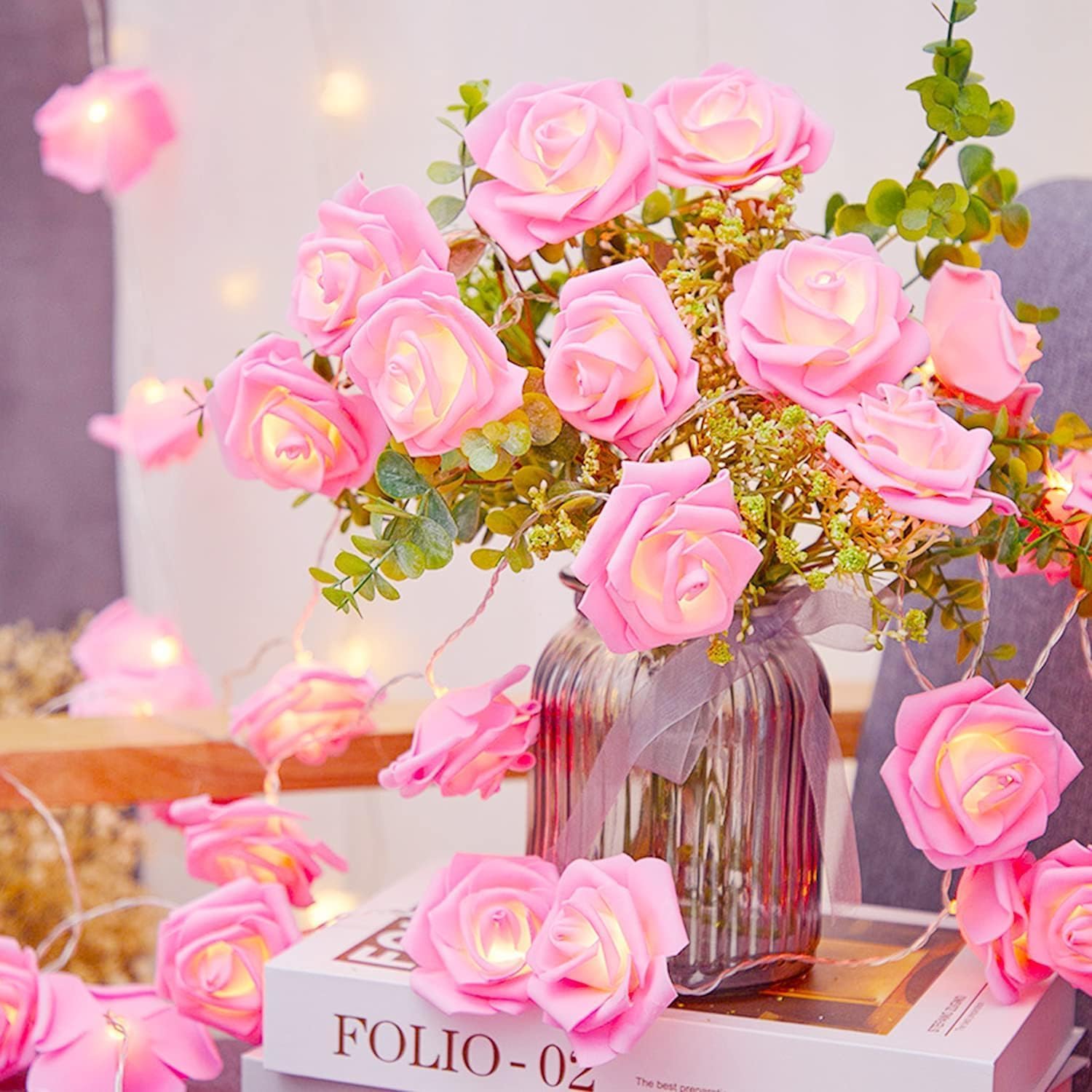 Delicate pink roses and twinkling fairy lights in a charming vase.