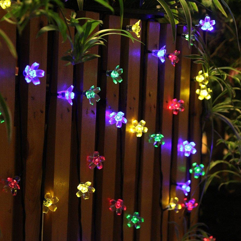 A lively assortment of flowers in various colors, elegantly lit by delicate lights, adding charm to the scene.
