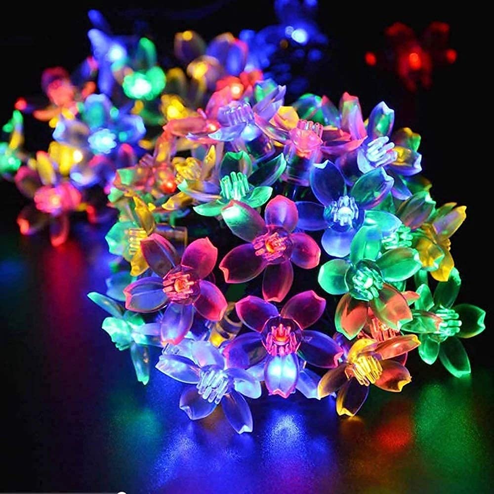 A cluster of bright, colorful flowers adorned with gentle lights, creating a cheerful and inviting atmosphere.