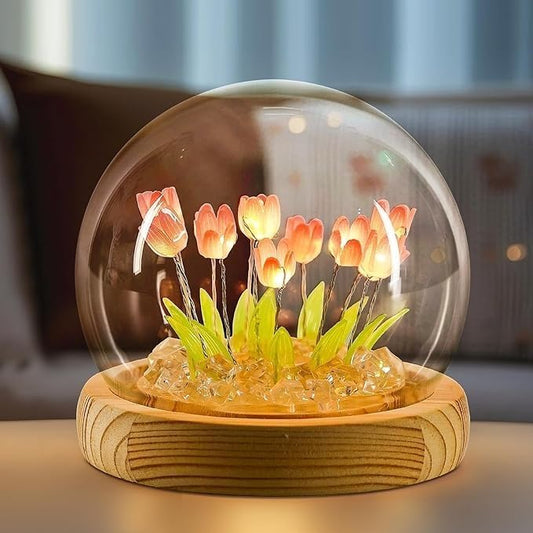 A glass dome containing a vibrant arrangement of colorful flowers, showcasing nature's beauty in a delicate display.