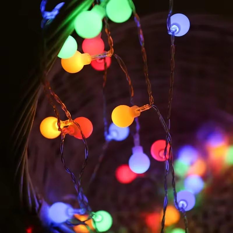 A string of bright Christmas lights wrapped around a white fence, adding a joyful touch to the winter landscape.
