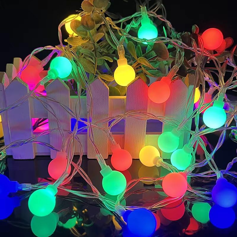 A colorful display of Christmas lights illuminating a white fence, enhancing the holiday spirit in the surroundings.
