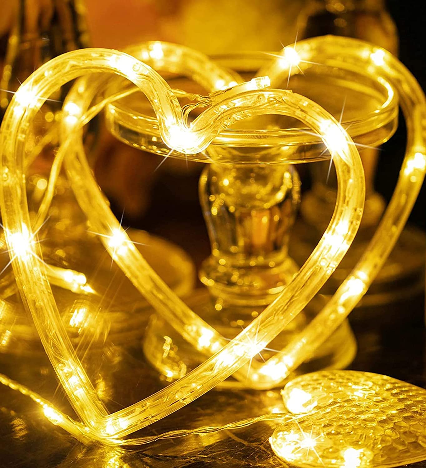 A glowing heart-shaped light inside a glass vase.