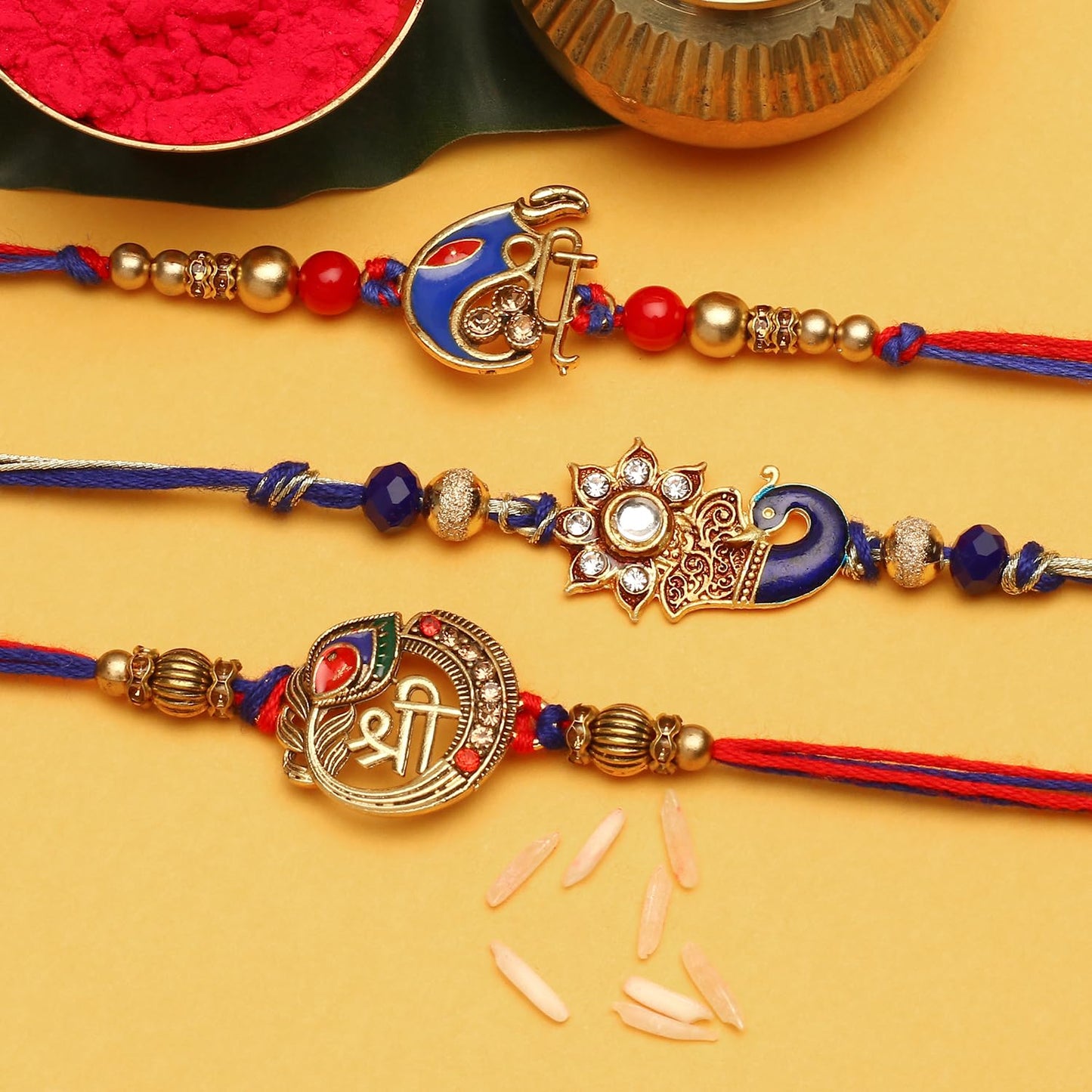 Three traditional rakhi with gold and red beads.